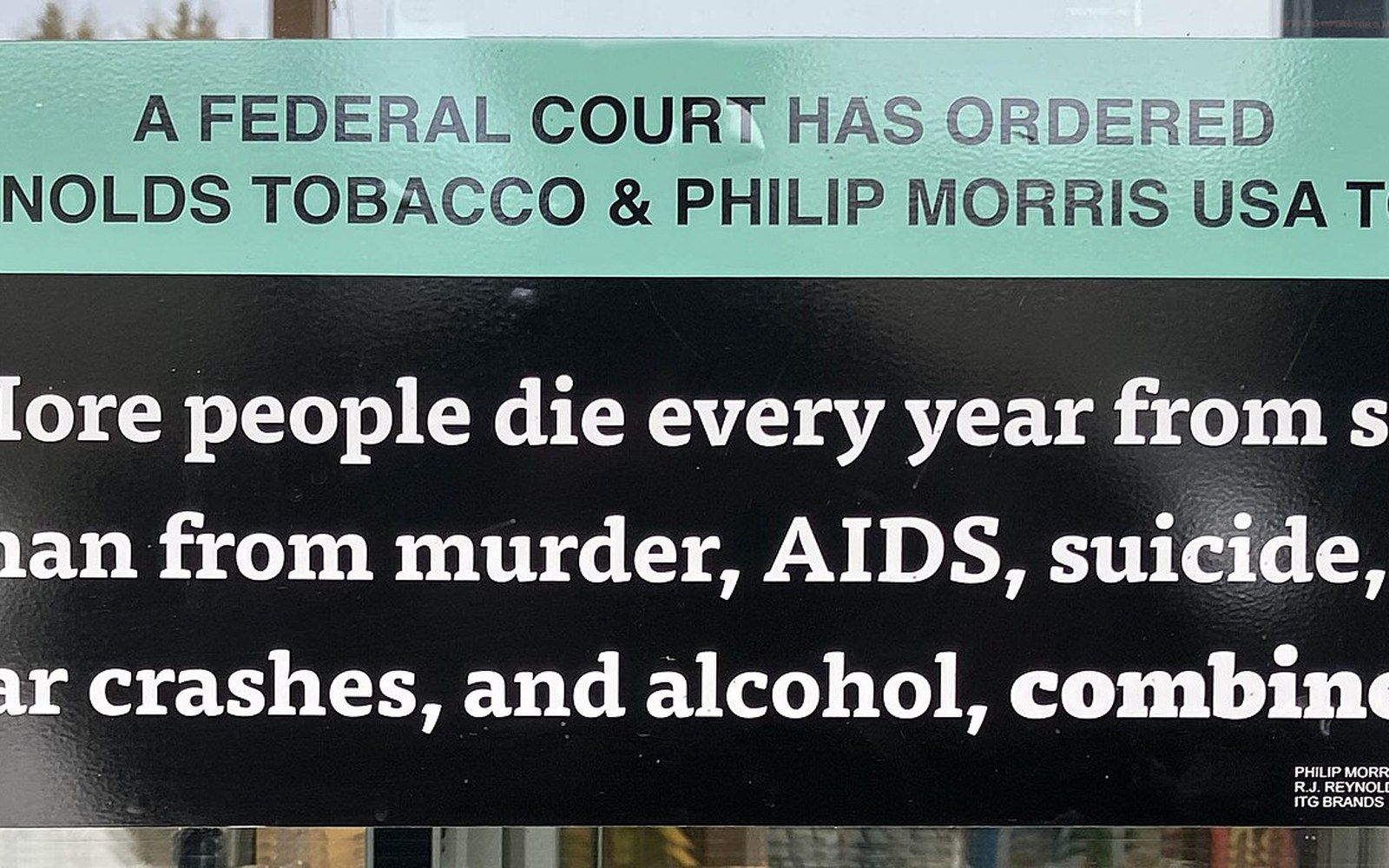 Court-ordered tobacco warning sign citing smoking deaths versus murder, AIDS, and car crashes combined