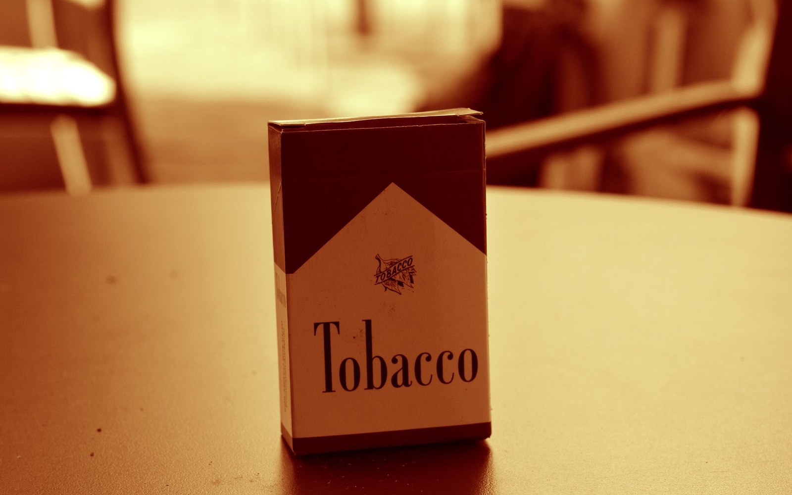 A generic tobacco cigarette pack standing upright on a café table