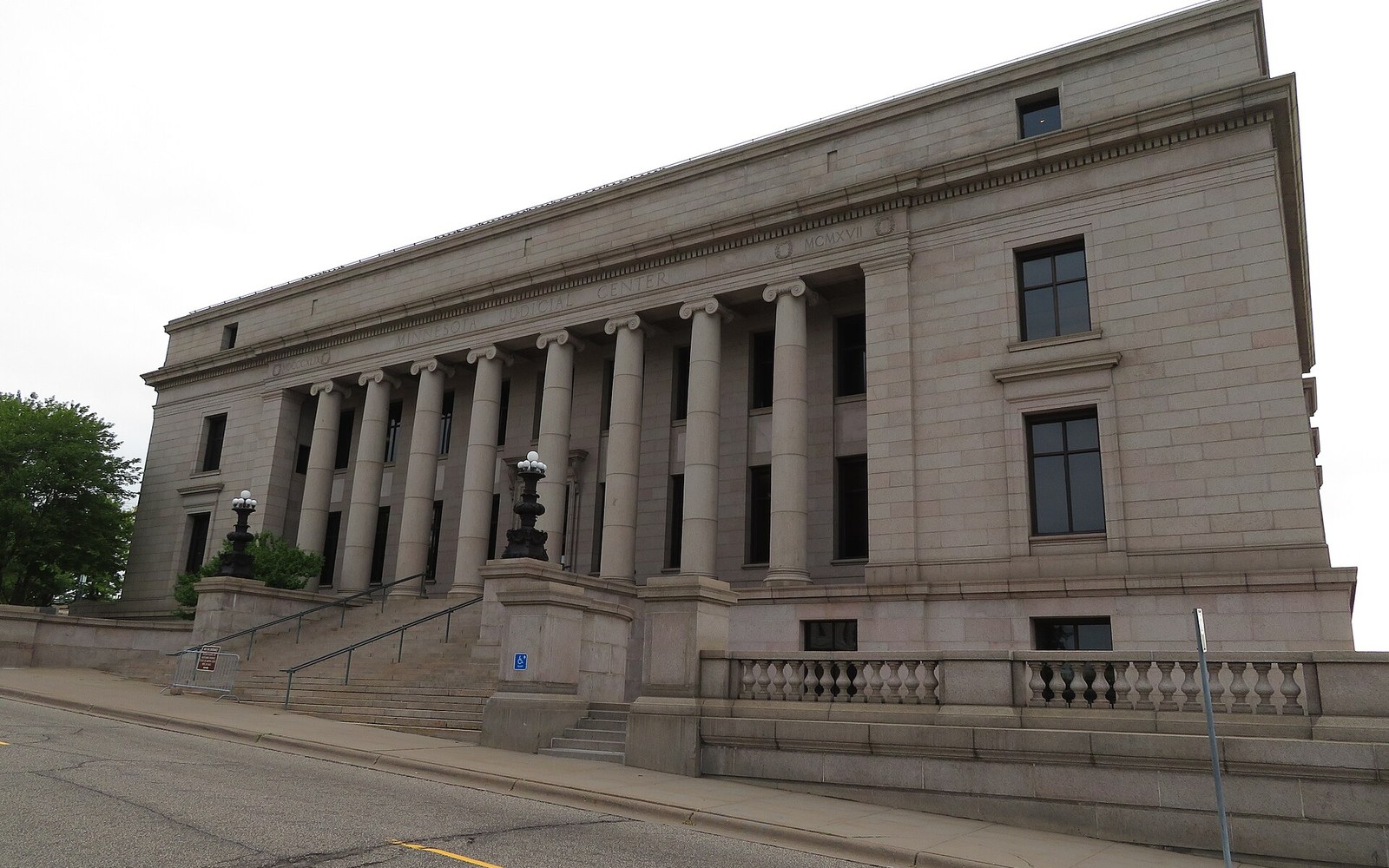 Neoclassical courthouse facade with tall Ionic columns and stone balustrade steps