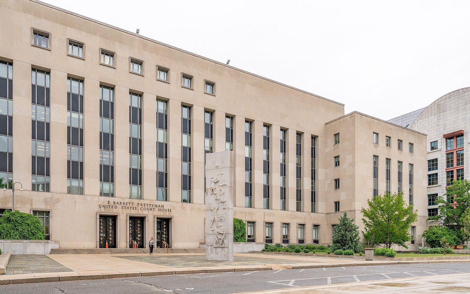 Exterior facade of the E. Barrett Prettyman United States Court House with a carved stone monument out front